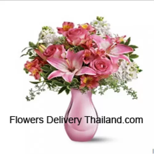 Roze rozen, roze lelies en diverse witte bloemen met wat varens in een glazen vaas